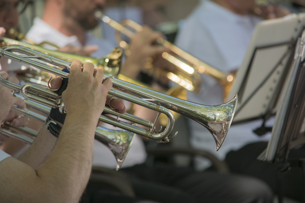 KI generiert: Eine Bläsergruppe spielt Trompeten bei einer Musikprobe.