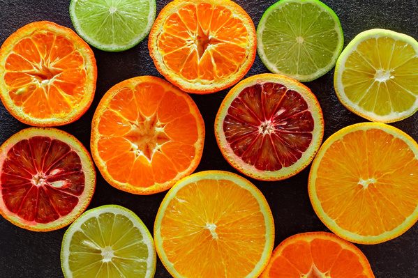 KI generiert: Verschiedene aufgeschnittene Zitrusfrüchte auf schwarzem Hintergrund.